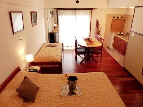 a room with two beds and a kitchen with a table at Apart Hotel Family in Mar del Plata