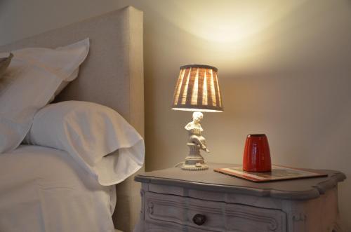 a lamp on a night stand next to a bed at Charmes d'hôtes in Grand-Leez