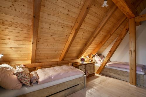 Dos camas en una habitación con paredes de madera. en Roubenka Štěpánka, en Svratka