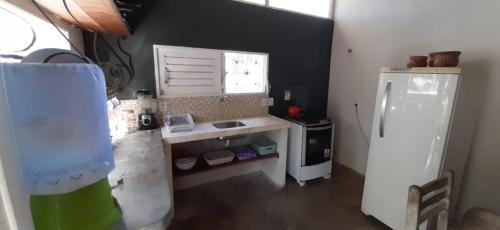 a small kitchen with a sink and a refrigerator at Stay Cool Pipa in Pipa