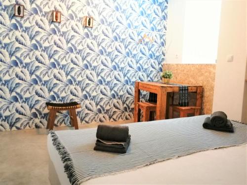a room with a bed with a blue and white wallpaper at Casa Blu Guesthouse - Casa de Hospedes in Santa Maria