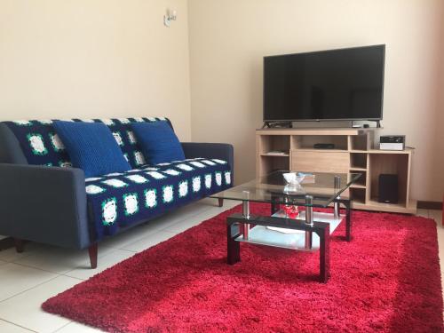 Una sala de estar con un sofá y una alfombra roja. en Casa Pucón, en Pucón