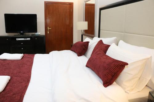 a bedroom with a white bed with red pillows at Over Mountains Hotel in Wadi Musa