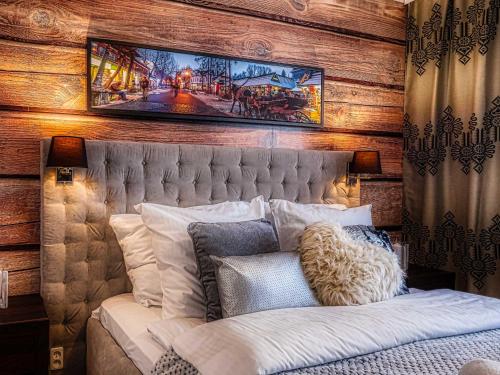 a bedroom with a bed with a painting on the wall at Apartament Krupówki Center in Zakopane