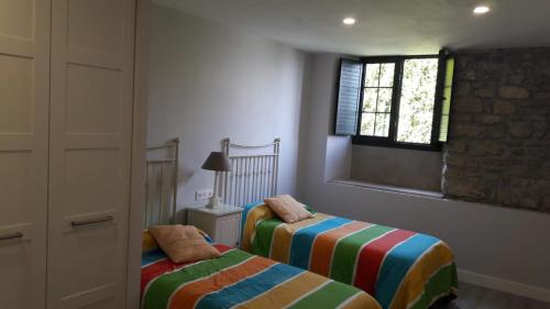 a bedroom with two beds and a window at Mirador del Cantábrico in Lastres