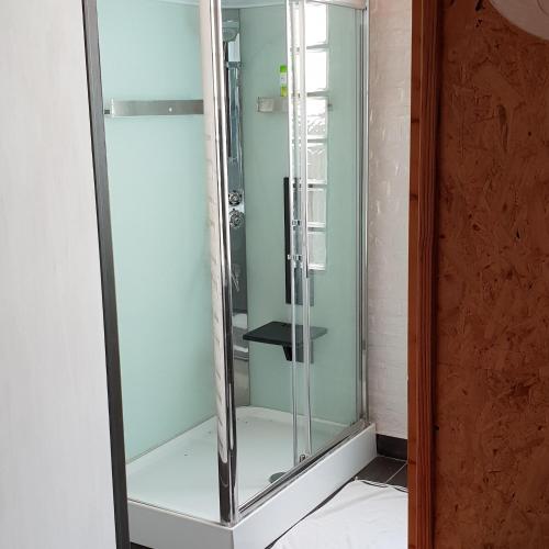 une douche dans une salle de bain avec une porte vitrée dans l'établissement LA POUDRIERE DE SAINT VENANT, à Saint-Venant