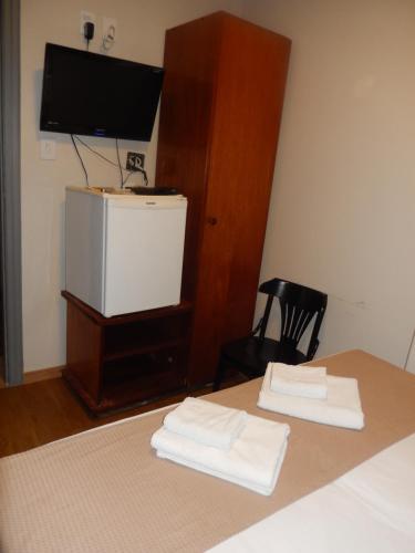 a bedroom with a television and a bed at Hotel Metropole in Belo Horizonte