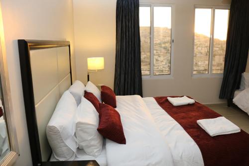 a bedroom with a large bed with red and white pillows at Over Mountains Hotel in Wadi Musa