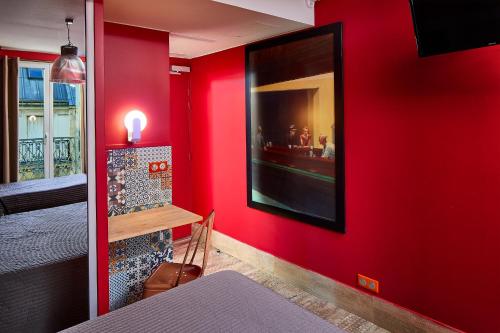 a room with a red wall with a picture on it at Hôtel de Roubaix in Paris