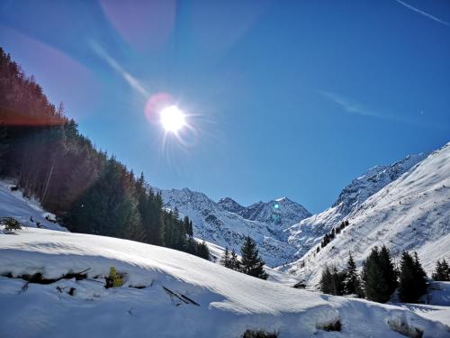 a snow covered mountain with the sun in the sky at Hotel Pension Siggi in Sankt Leonhard im Pitztal
