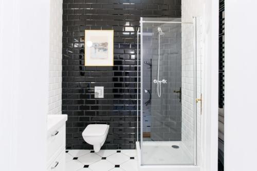uma casa de banho com um WC e uma cabina de duche em vidro. em Apartament Nowe Miasto - Skwer Malarzy em Gorzów Wielkopolski