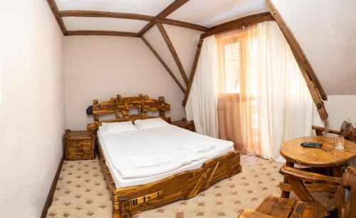 a bedroom with a wooden bed and a table at Complex Hyzhky in Yaremche