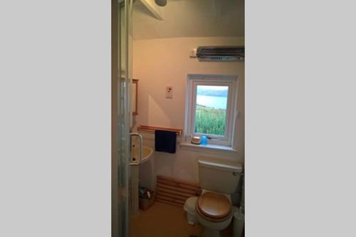 a bathroom with a toilet and a window at Bothan na Tilleadh in Achiltibuie