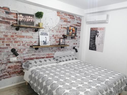 1 dormitorio con cama y pared de ladrillo en Mezquita- Elite, Parking, Wifi, en Córdoba