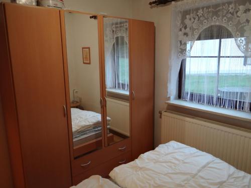 ein Schlafzimmer mit einem großen Holzschrank und einem Bett in der Unterkunft Ferienwohnung Neumann Feriendorf Hoher Bogen Haus 41 in Arrach