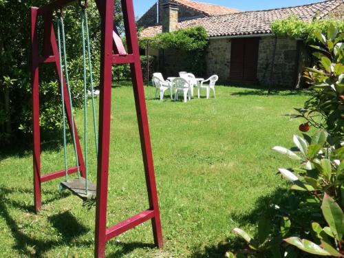 a red ladder in a yard with chairs at Casa El Prado de la Romia in Argüero