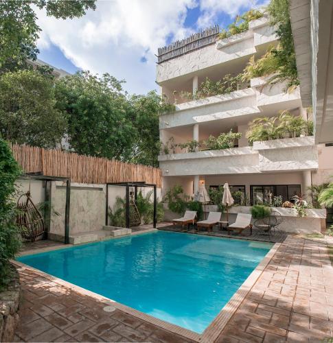a swimming pool in front of a building at Che Suites Tulum in Tulum