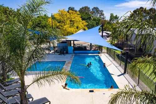 einen Blick über einen Pool mit Menschen darin in der Unterkunft Barwon River Holiday Park in Geelong