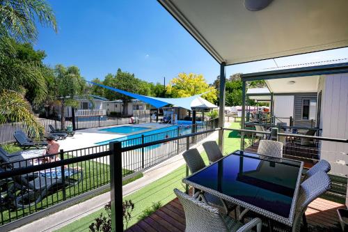 a balcony with a table and chairs and a swimming pool at Barwon River Holiday Park in Geelong
