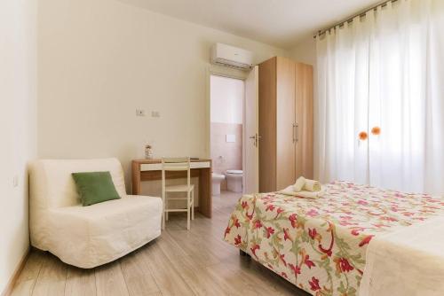 ein Schlafzimmer mit einem Bett, einem Stuhl und einem Schreibtisch in der Unterkunft Leolù Guesthouse Alghero in Alghero