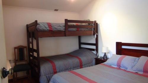 a bedroom with two bunk beds and a bed at Hostal Los Avellanos in Temuco