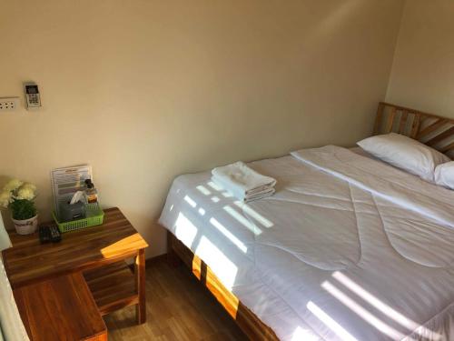 a bedroom with a bed and a wooden nightstand with a bed sidx sidx sidx at เชียงคาน เรสติ้ง เพลส in Chiang Khan