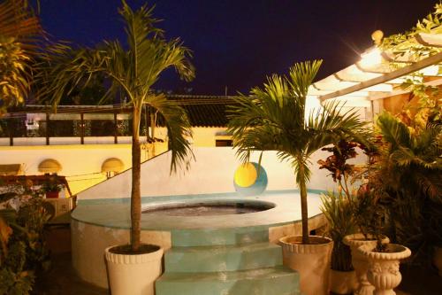 a pool with two palm trees in a courtyard at Hotel Casa Gloria Boutique in Cartagena de Indias