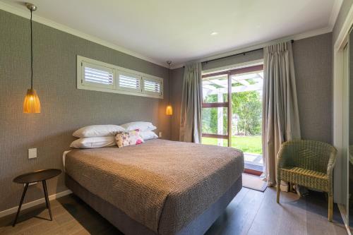 Un dormitorio con una cama grande y una ventana en Accent House Luxury Boutique Bed & Breakfast, en Mapua