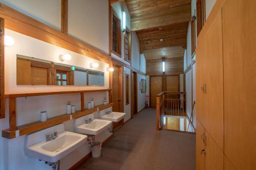 a bathroom with three sinks and two mirrors at North Point in Niseko