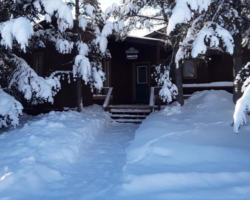 a house with a pile of snow in front of it at Faithful Street Inn in West Yellowstone