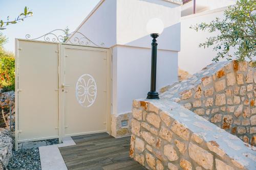 a gate to a house with a stone wall at Una Perla Nel Verde in Putignano
