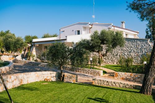 a house with a stone wall and a yard at Una Perla Nel Verde in Putignano