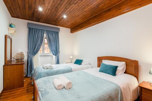 Un dormitorio con dos camas y una ventana. en Casa Outeiro de Cima - Casa Rústica típica Serrana - Seia - SERRA DA ESTRELA, en Seia