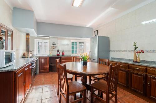 a large kitchen with a wooden table and chairs at Casa Outeiro de Cima - Casa Rústica típica Serrana - Seia - SERRA DA ESTRELA in Seia