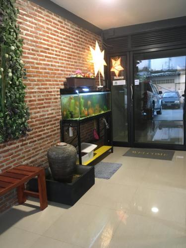 um quarto com um aquário ao lado de uma parede de tijolos em ICON HOSTEL em Bangkok