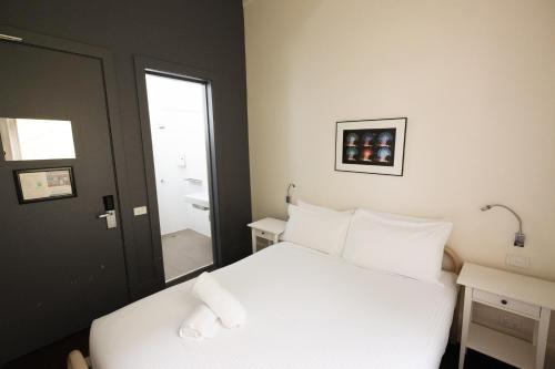 a bedroom with a white bed with two towels on it at YHA Melbourne Central in Melbourne