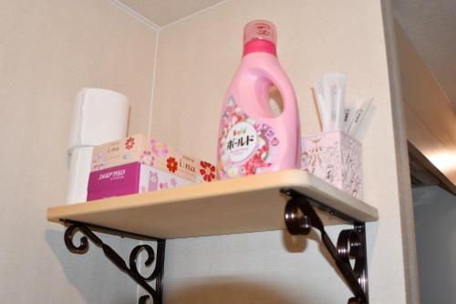 a shelf with a pink bottle and other items on it at Cozyhouse 310 free wifi a rented electric bicycle in Kyoto