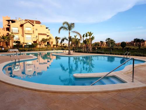 duży basen z drzewami i budynkami w tle w obiekcie Casa Colin - Mar Menor Golf Resort w mieście Torre-Pacheco
