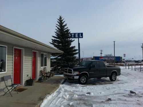 a black truck parked in front of a building at Motel 66 in Transcona