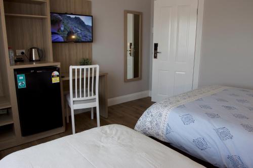 a bedroom with a bed and a desk and a tv at Carnarvon Lodge Kirribilli, Sydney in Sydney
