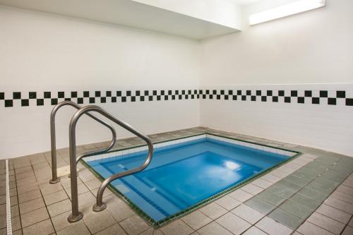 a hot tub in a bathroom with a metal hand rail at Baymont by Wyndham Helena in Helena