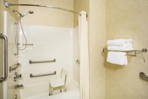 a bathroom with a tub and a shower with towels at Baymont by Wyndham Helena in Helena