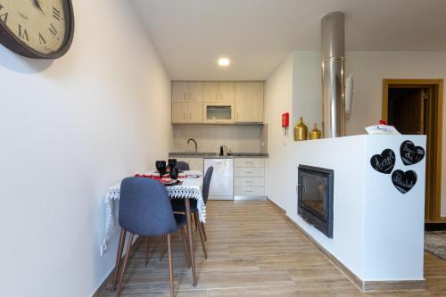a kitchen with a table and a clock on the wall at Villa Alzira in Seia