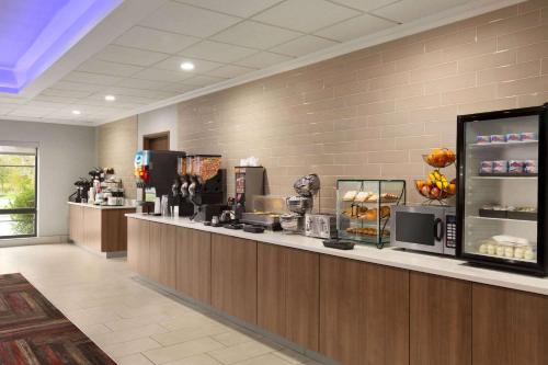 a restaurant with a counter with aasteryasteryasteryasteryasteryasteryasteryasteryastery at La Quinta by Wyndham Lackawanna in Lackawanna