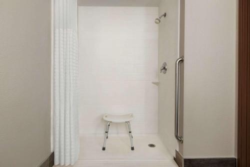 a stool in a bathroom with a shower at La Quinta by Wyndham Lackawanna in Lackawanna