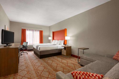 a hotel room with a bed and a couch at La Quinta by Wyndham Lackawanna in Lackawanna