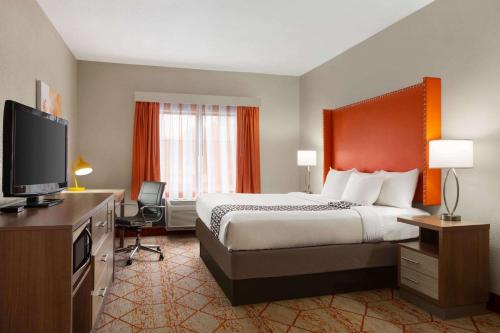 a hotel room with a bed and a flat screen tv at La Quinta by Wyndham Lackawanna in Lackawanna