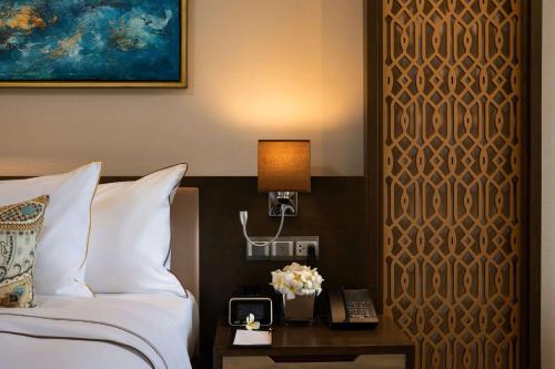 a hotel room with a bed and a phone on a table at Wyndham Grand KN Paradise Cam Ranh in Cam Ranh