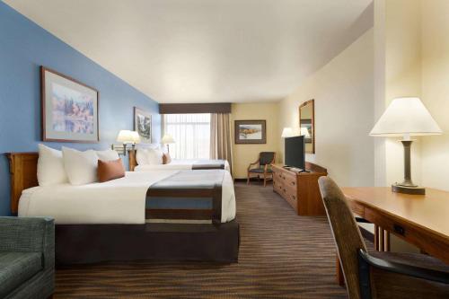 um quarto de hotel com duas camas e uma secretária em Wingate by Wyndham Denver Tech Center em Greenwood Village