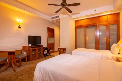 a hotel room with two beds and a flat screen tv at Royale Chulan Kuala Lumpur in Kuala Lumpur